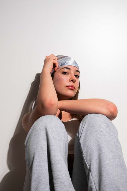 Retrato en estudio de una modelo sentada sobre fondo claro