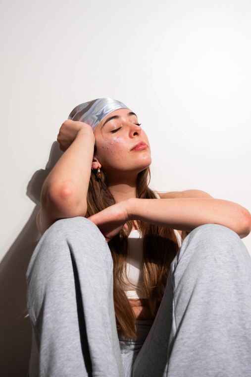 Retrato en estudio con la modelo apoyando la cabeza en el brazo